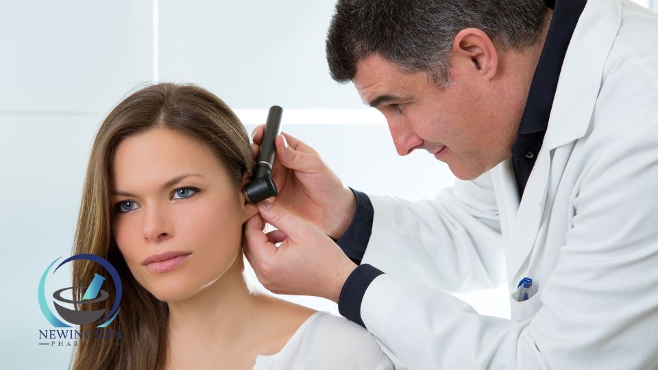male doctor examining ear of female patient