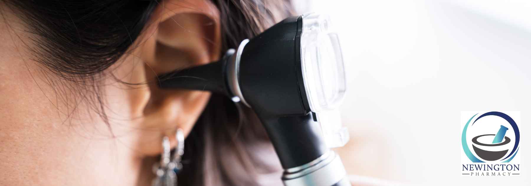 doctor examining ear of female patient