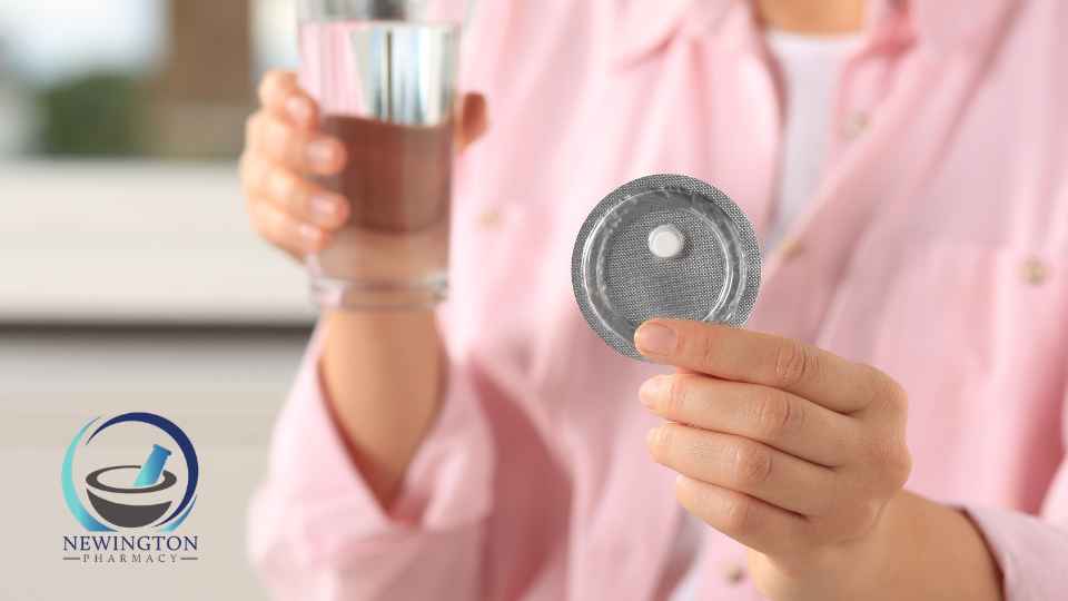 woman holding glass of water and emergency contraceptive pill