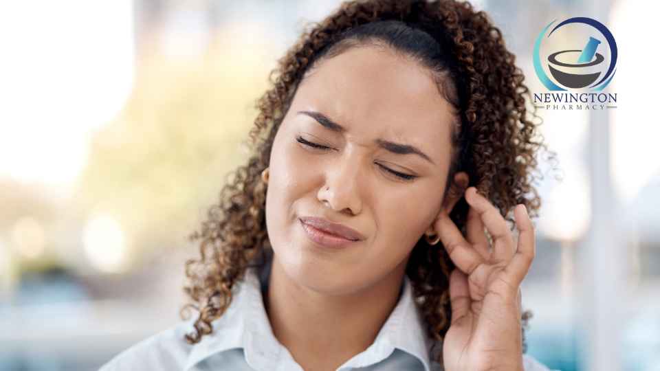 woman clutching ear in discomfort