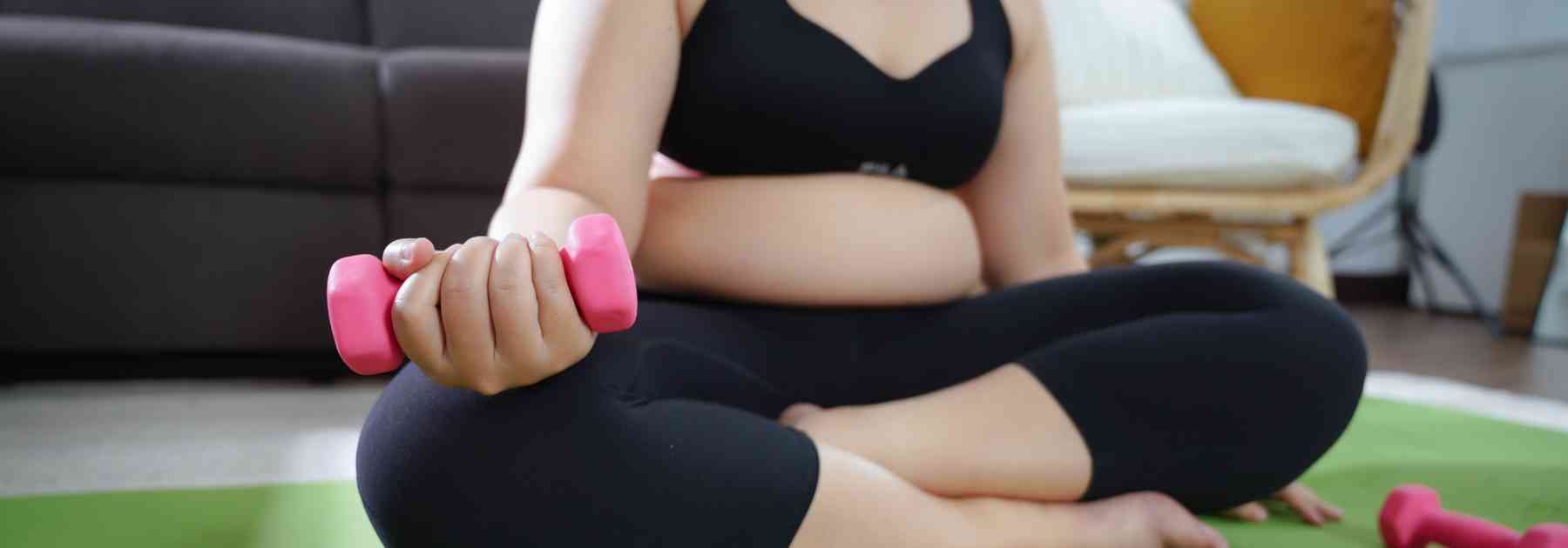 overweight woman in workout gear lifting weight