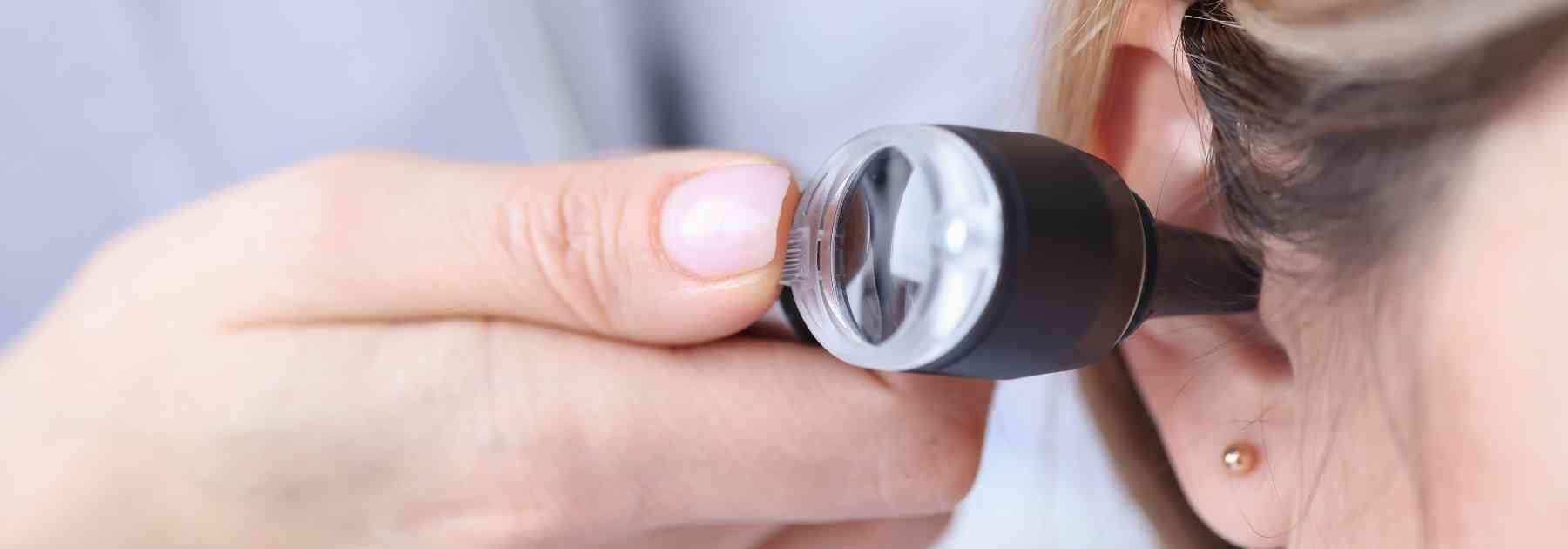 doctor inspecting ear of female patient