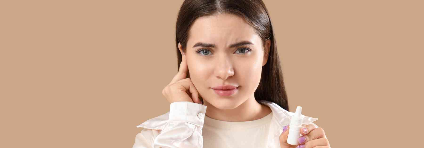 girl holding bottle of ear drops