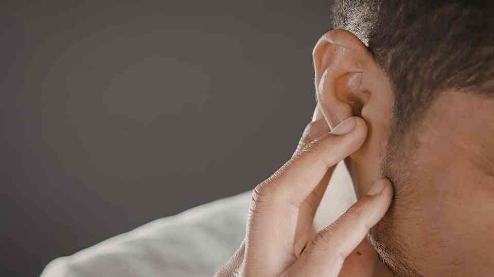 man clutching ear in discomfort