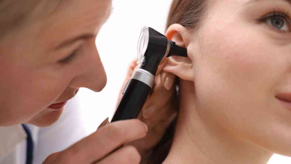 doctor looking in ear of female patient
