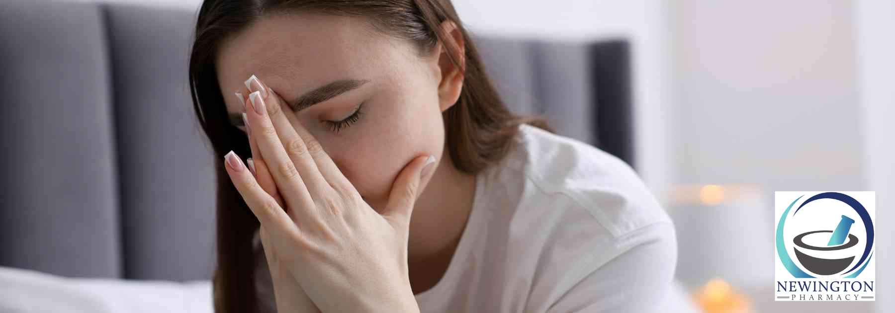 woman sitting on bed looking tired