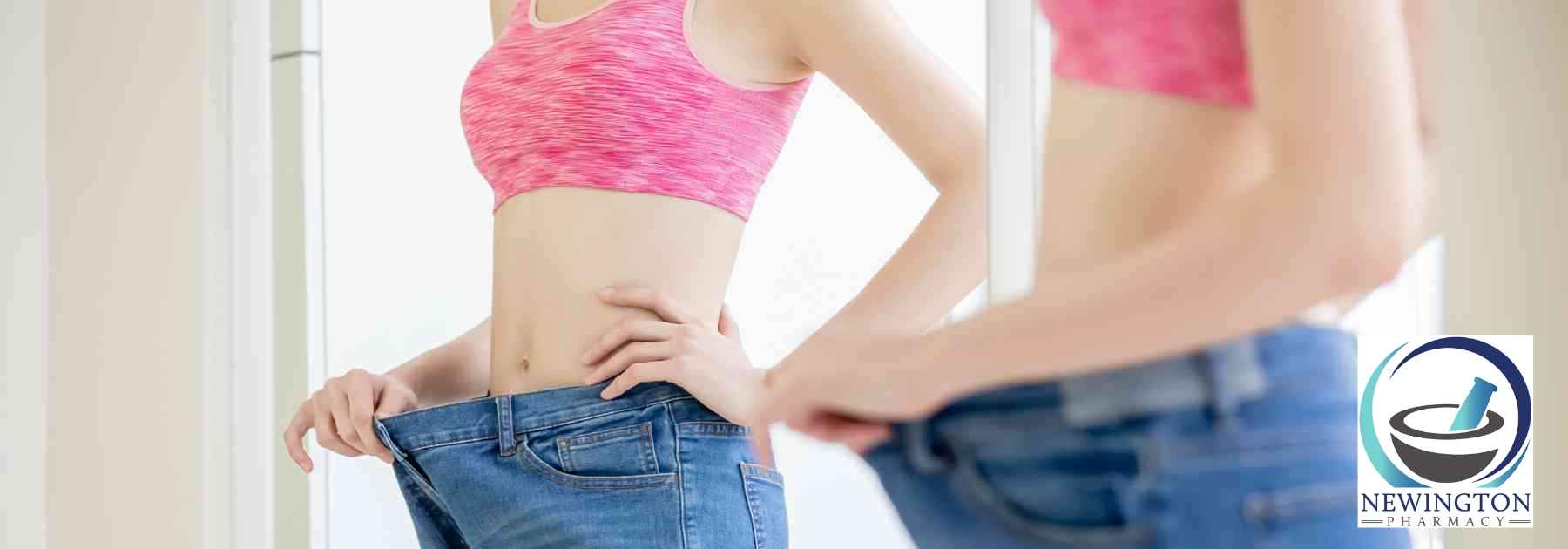 woman looking in mirror wearing jeans too big