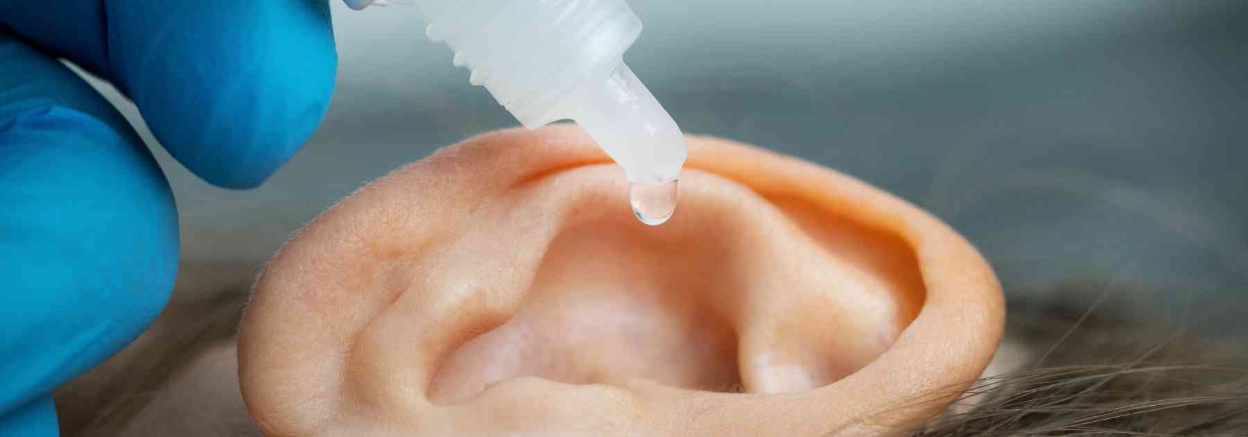 close-up of person inserting ear drops into their ear
