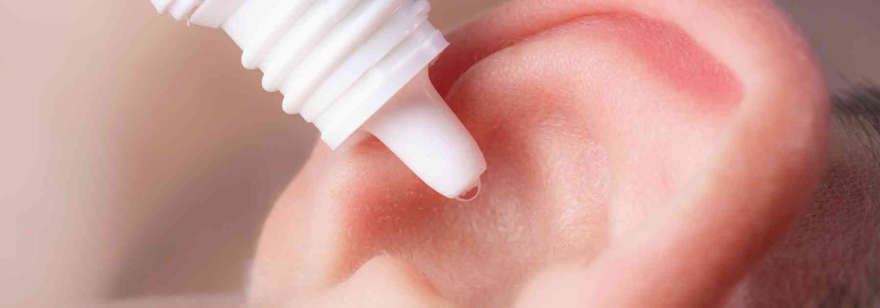 close-up of person putting ear drops in ear