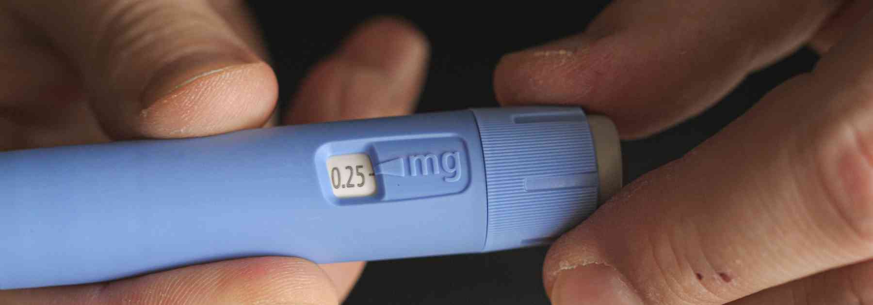 close-up of person holding weight loss injection