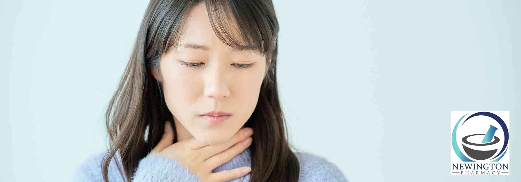 woman clutching her thyroid area