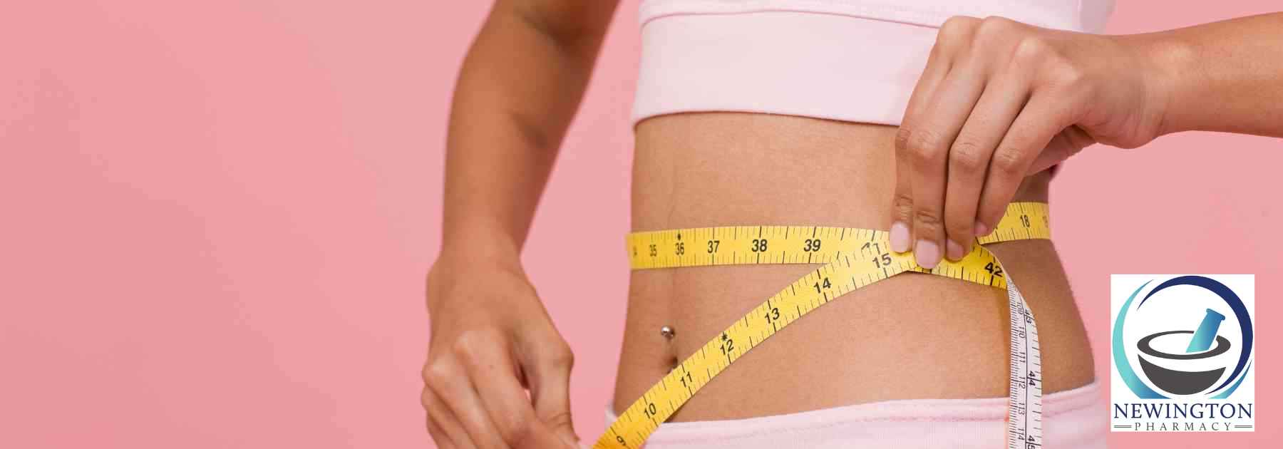 woman measuring her waist against pink background