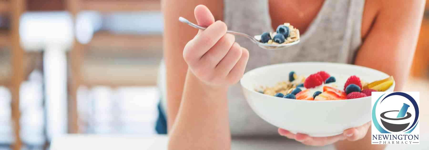 woman eating berries from bowl with spoon
