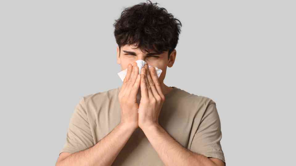 young man blowing his nose