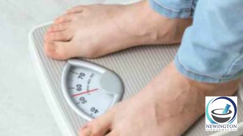 person in blue jeans and bare feet standing on scales