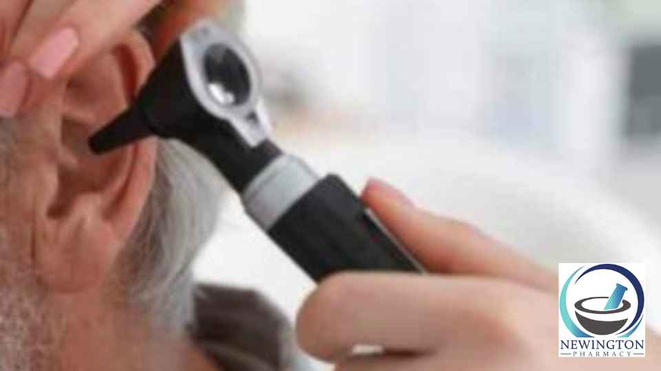 doctor examining ear of older male patient