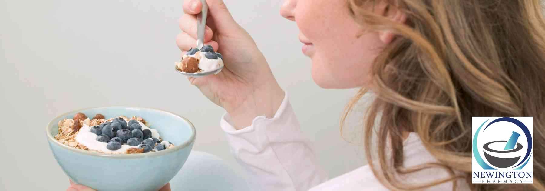 woman eating berries from bowl with spoon
