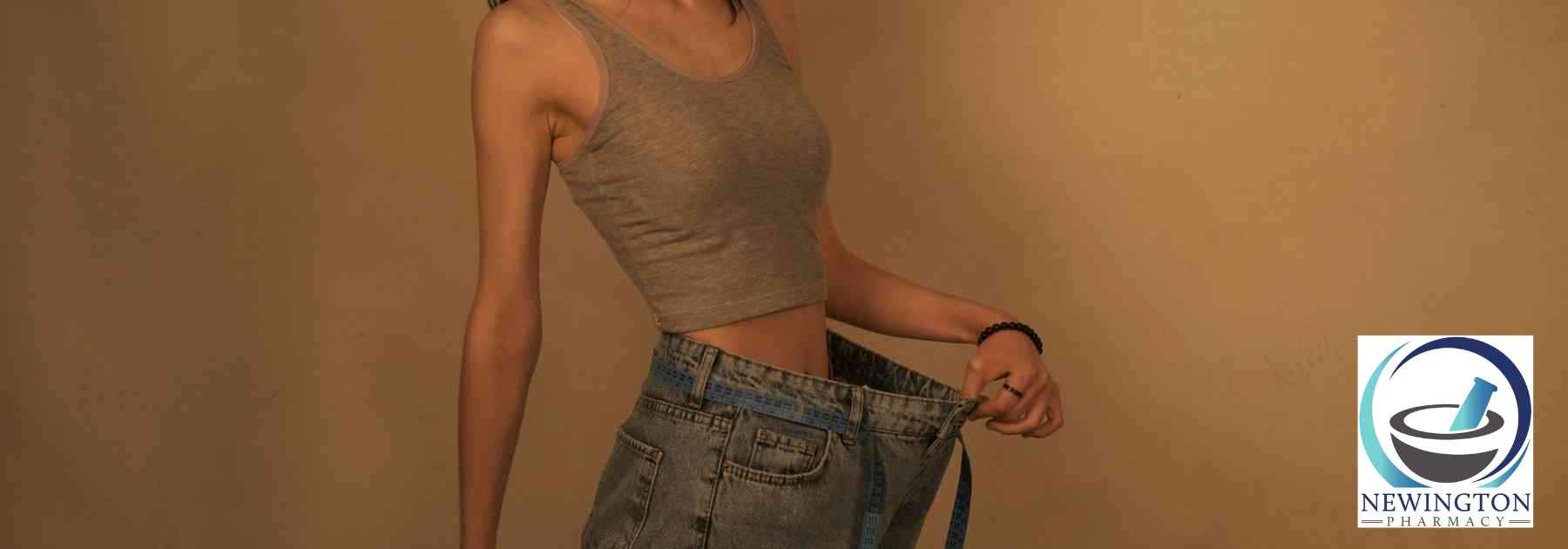 woman wearing jeans too big on orange background