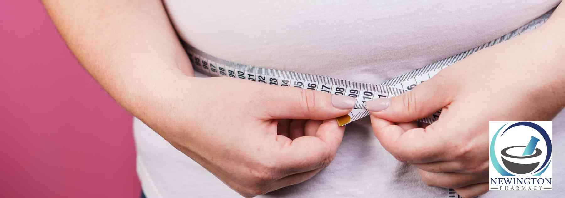 overweight woman measuring waist on pink background