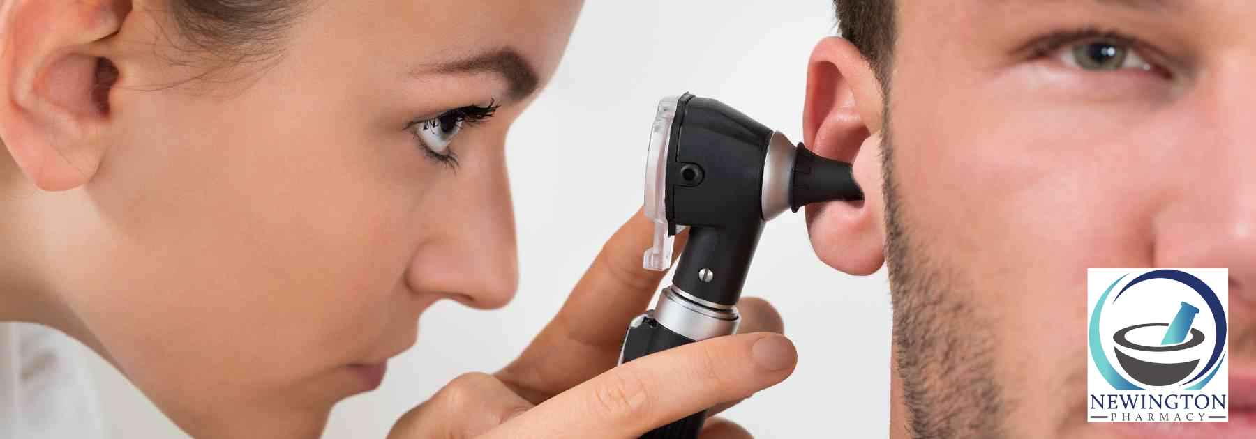 female medical professional examining ear of male patient