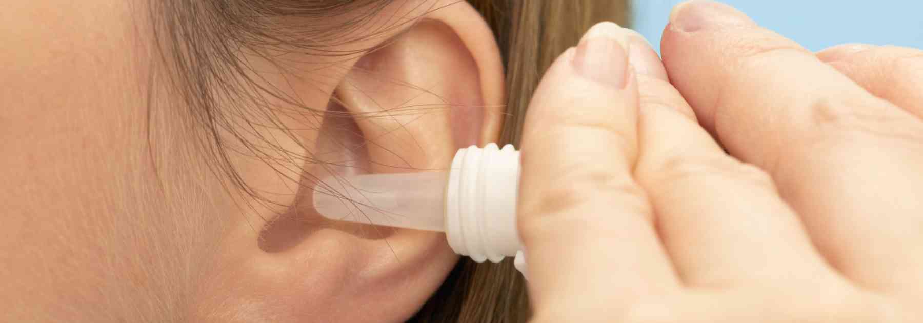 close-up of woman using ear drops