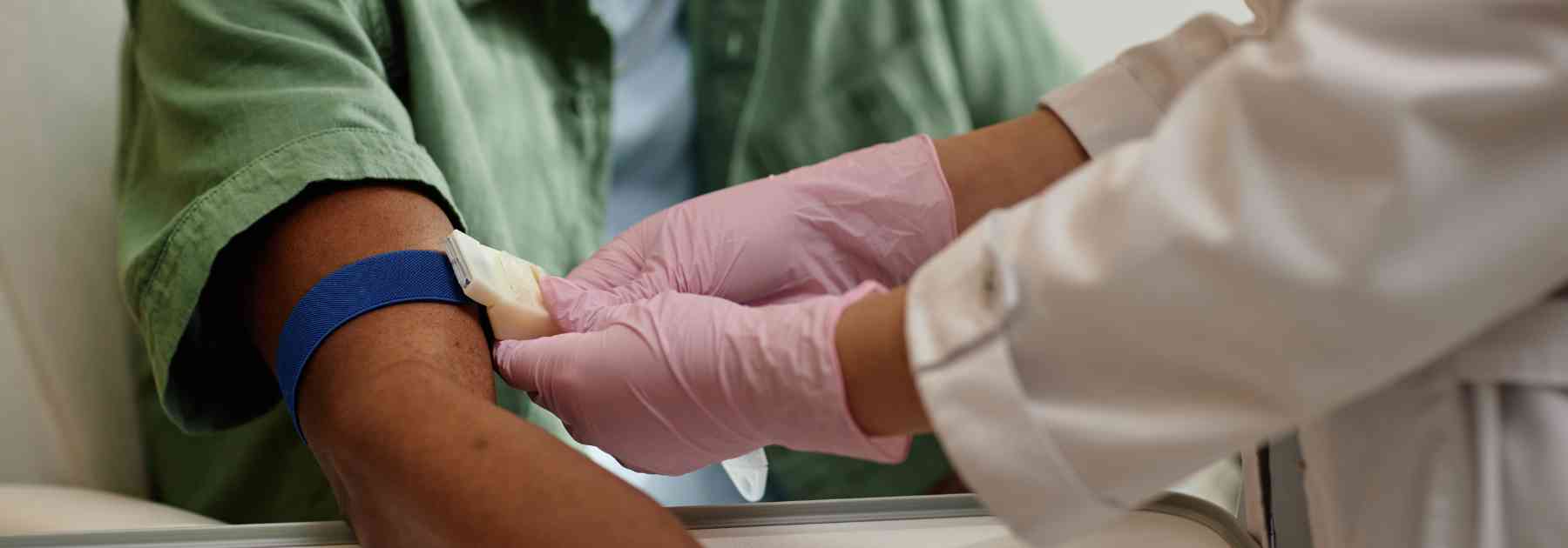 patient in green shirt receiving blood test