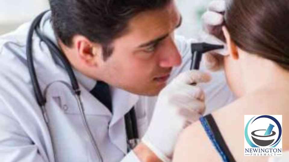 male doctor examining ear of female patient