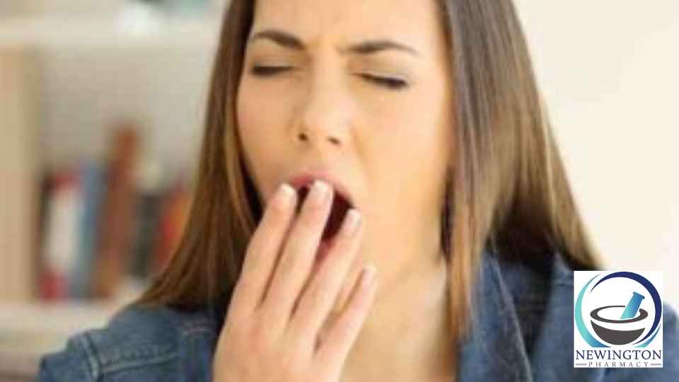 woman sitting on couch yawning