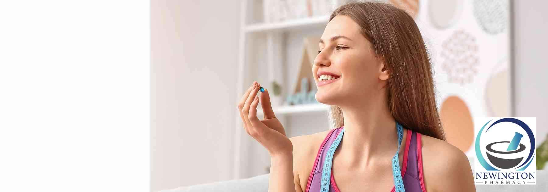 young woman smiling holding weight loss supplement