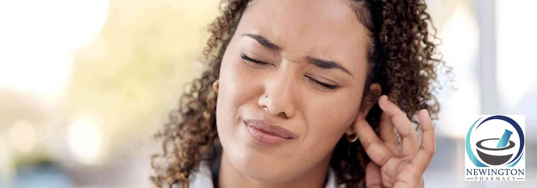 woman holding ear in discomfort