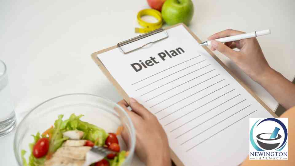 person holding pen and diet plan sheet on clipboard next to healthy food