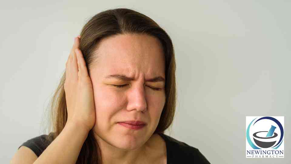 woman clutching her ear in discomfort