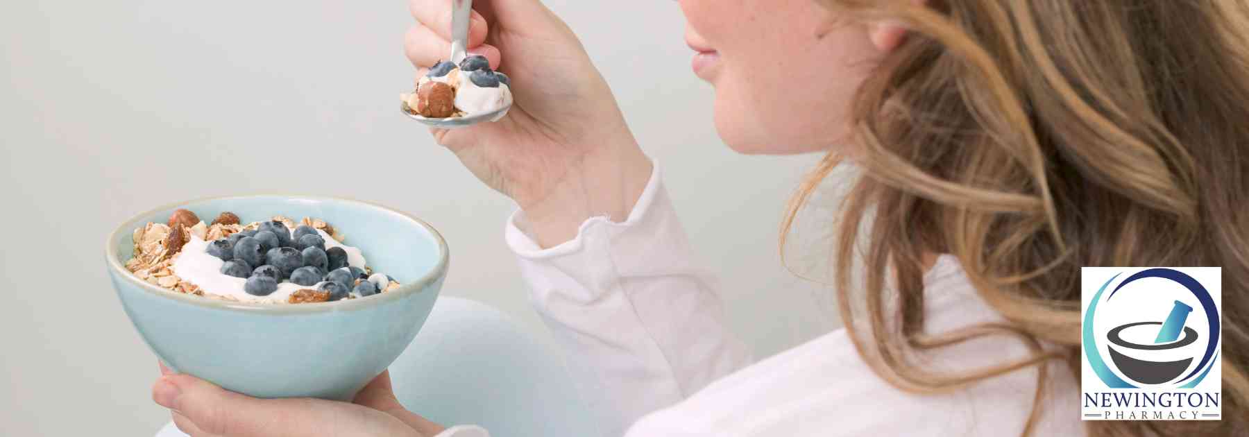 woman eating berries from bowl with spoon