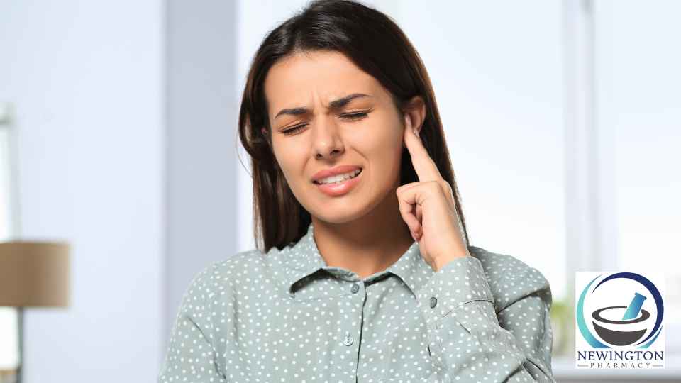 young woman rubbing her ear in discomfort