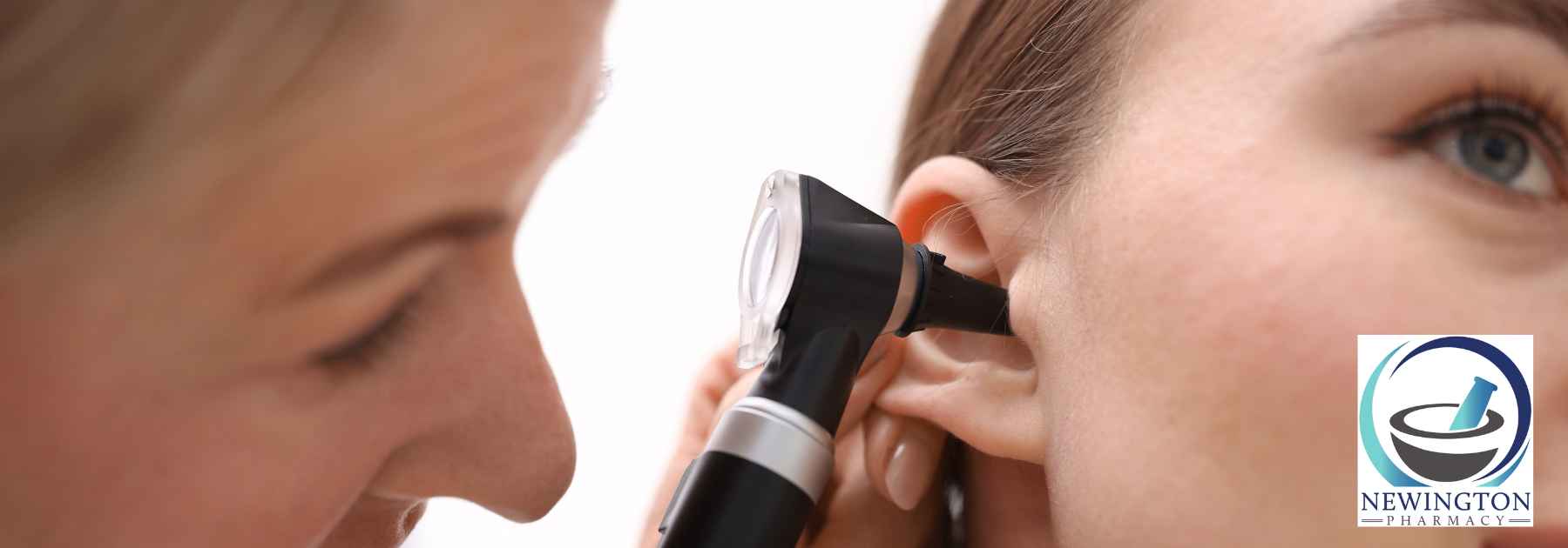 doctor examining ear of female patient